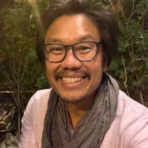 Head Shot of Jiho Sohn. Smiling wearing glass and scarf.